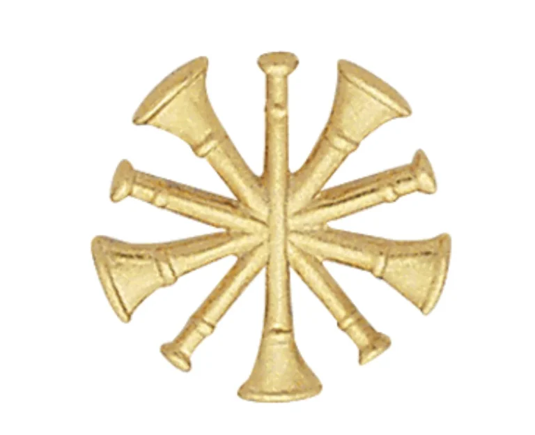A gold insignia featuring six trumpets arranged in a radial pattern, with their bells pointing outward. The design is symmetrical and detailed.